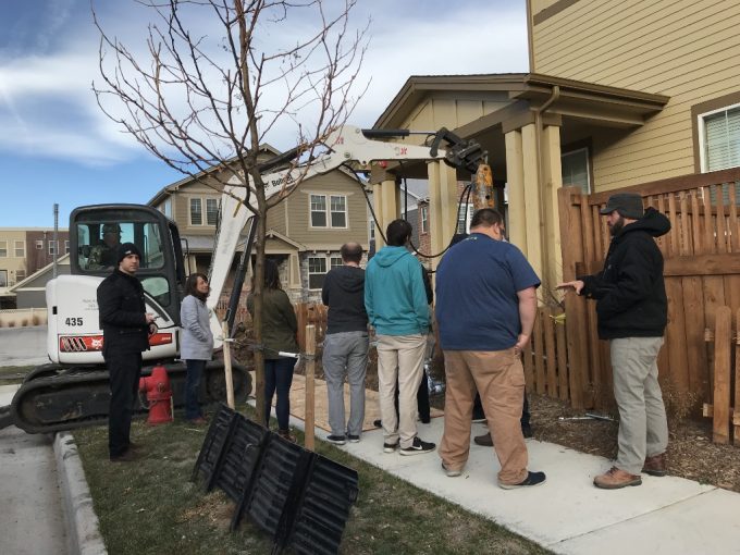 Structural engineers observe helical pier installation.