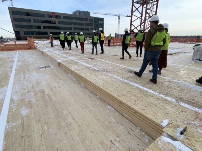A group of people are shown touring the construction at T3, which is a Mass Timber construction project.