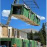 Volumetric construction process photo: module being lifted by a crane.