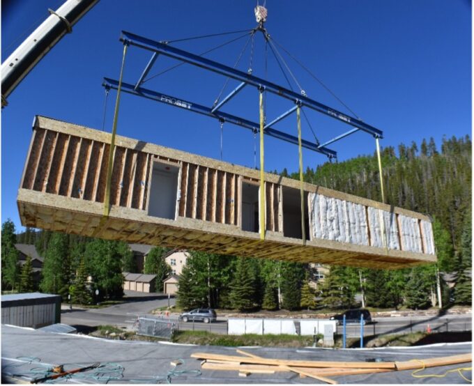 The interior side of a volumetric construction module while in motion being set.