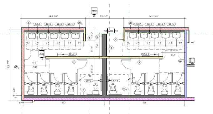 A partitioned restroom with a central wall separating the sinks from the toilets