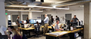 EVstudio employees, including entry-level employees, collaborating at standing desks in the office
