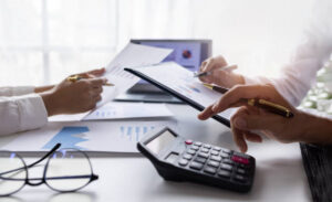A/E firm controller and project manager reviewing financial charts with a calculator