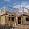 Two-story residential home under construction showing OSB shear wall sheathing and wood framing