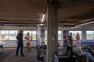 Wide view of the EVstudio Denver office during the happy hour, with project banners, a ping pong table, and mountain views Caption: Our Denver office, dressed up for the occasion