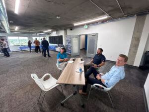 EVstudio and Fransen Pittman team members seated at a table with food and drinks during a Friday happy hour Caption: Plates full, laptops closed